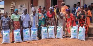 An elderly community member receiving a sack of maize flour from staff at Kabubbu’s maize mill.